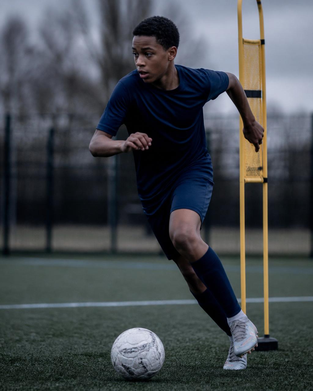 Pathway Football Academy youth player in an intense solo dribbling drill, chasing the highest standard